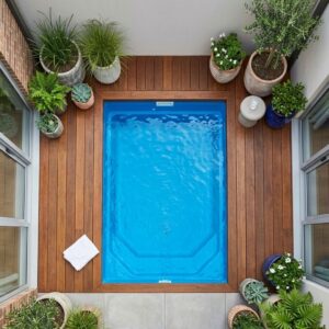 A compact polyurea plunge pool efficiently integrated into a modern townhouse patio garden.